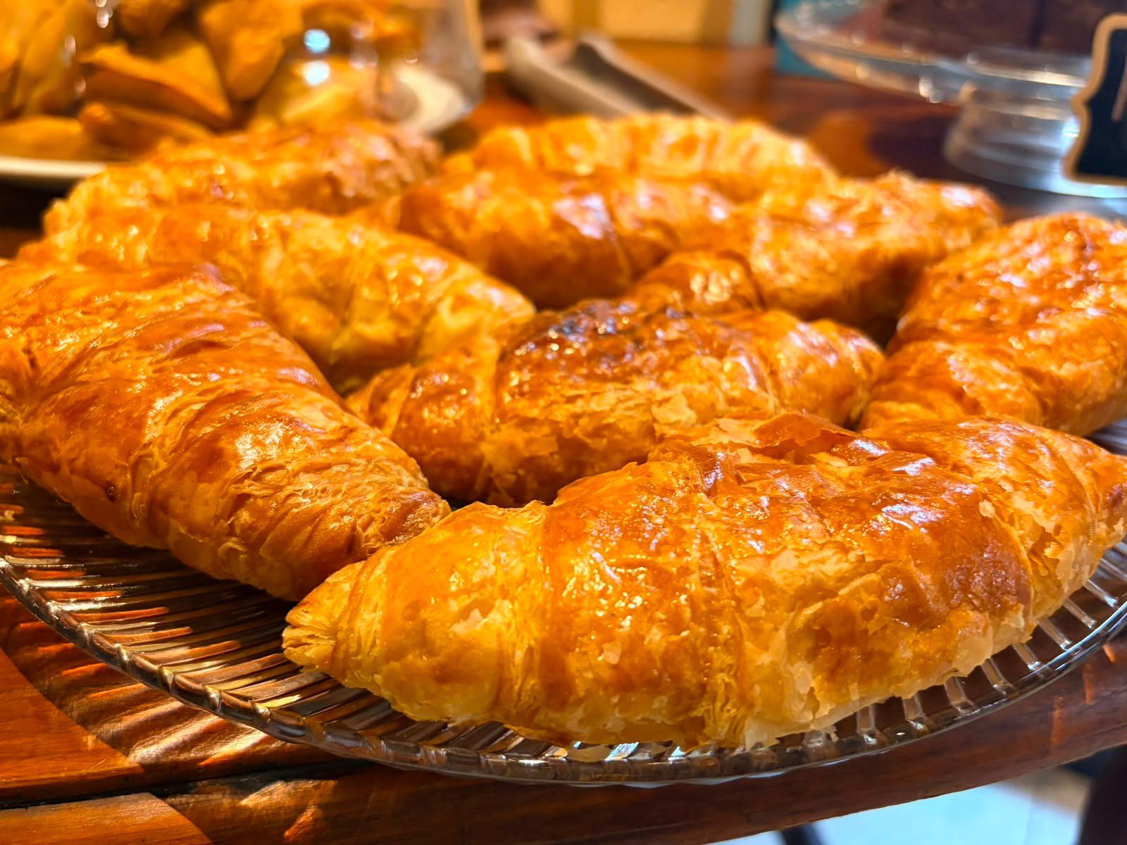 Golden croissants on a glass platter