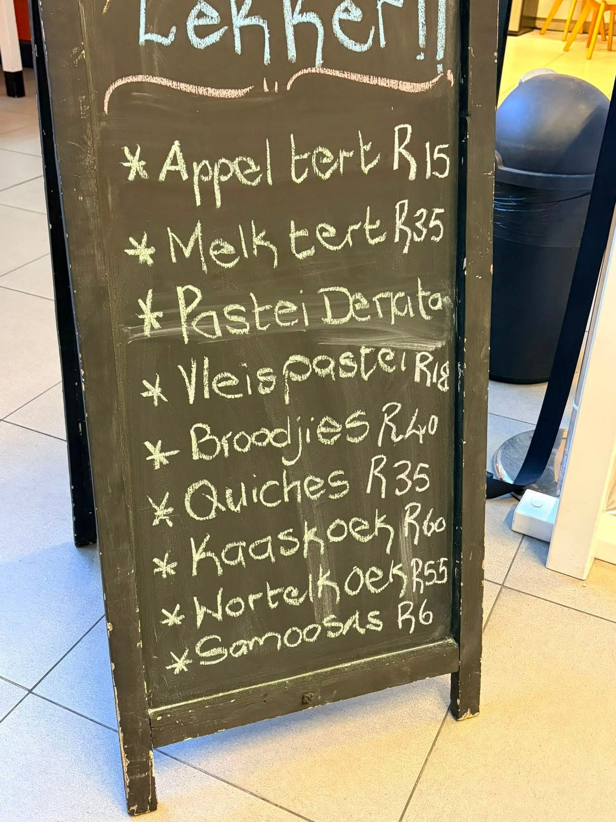 The chalkboard price list, written up by hand